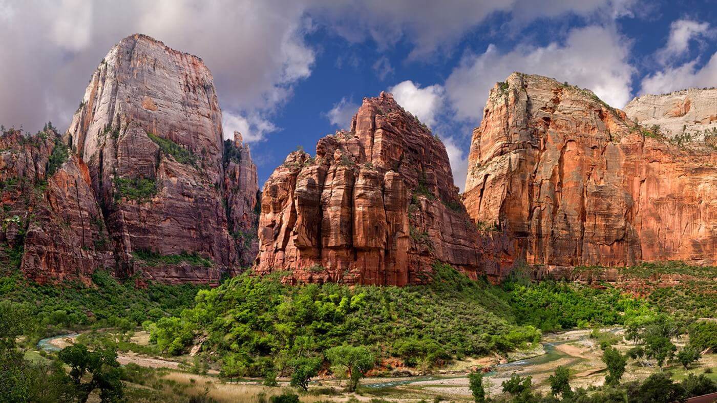 Falaises de grès rouge du parc national de Zion en Utah avec végétation verdoyante et méandres de la rivière Virgin
