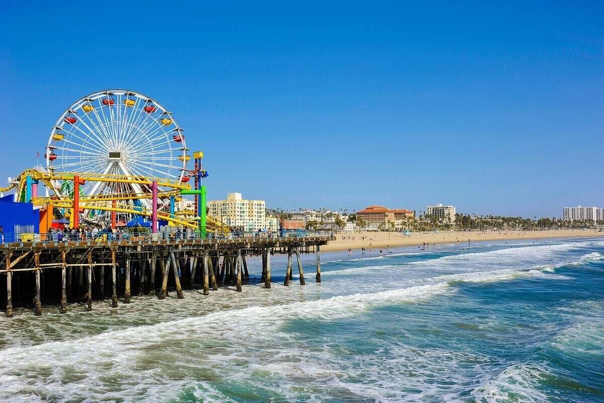 Grande roue colorée sur la jetée de Santa Monica avec la plage de Los Angeles et l'océan Pacifique