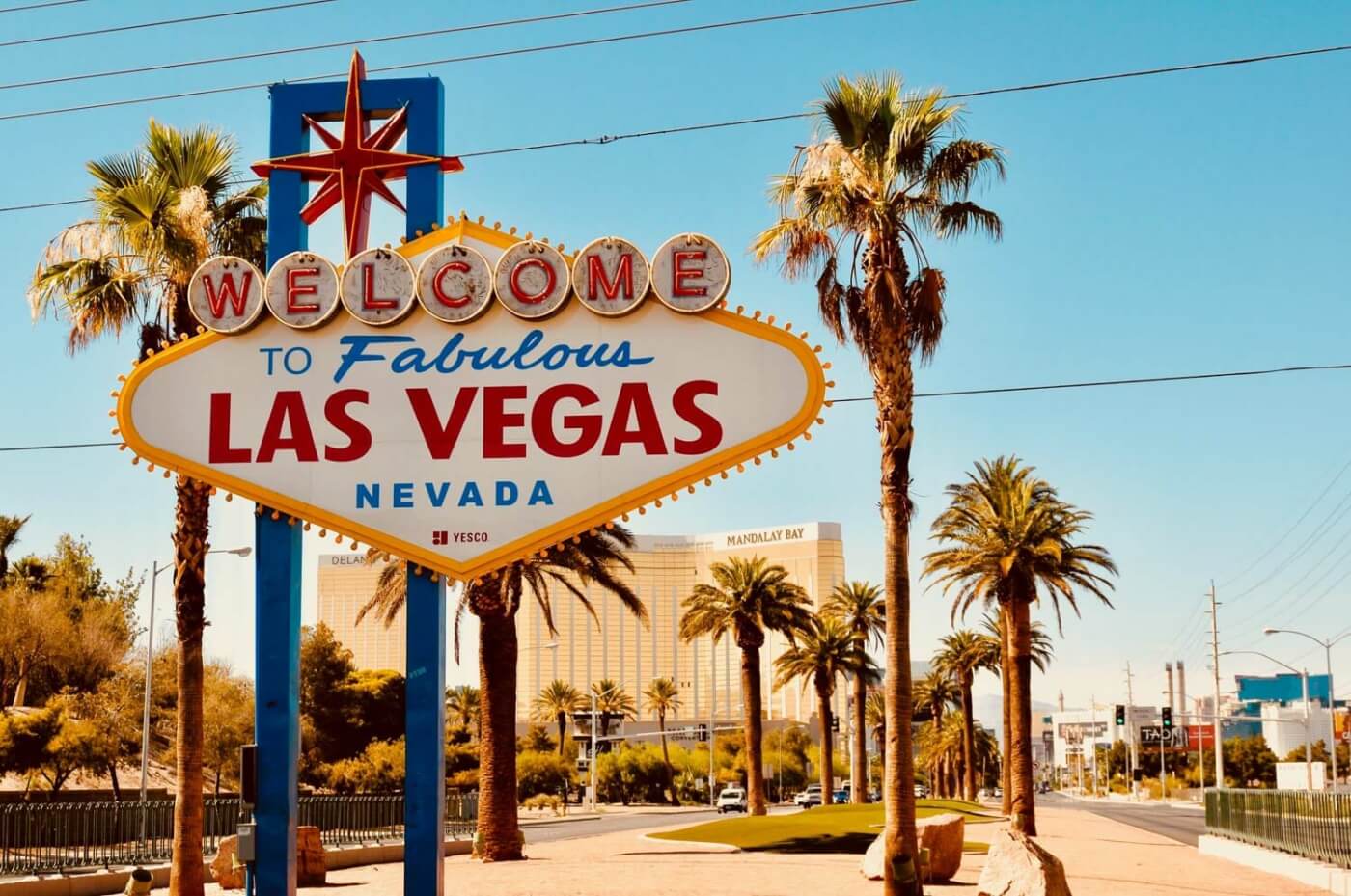Panneau iconique Welcome to Fabulous Las Vegas Nevada entouré de palmiers sous un ciel bleu dégagé