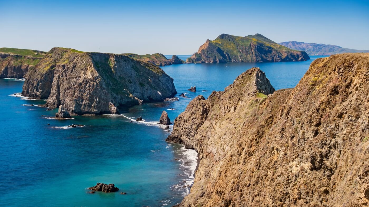Falaises rocheuses du parc national des &icirc;les Anglo-Normandes surplombant l'oc&eacute;an Pacifique bleu sous un ciel d&eacute;gag&eacute;